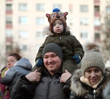 gyermek ül egy férfi nyakában